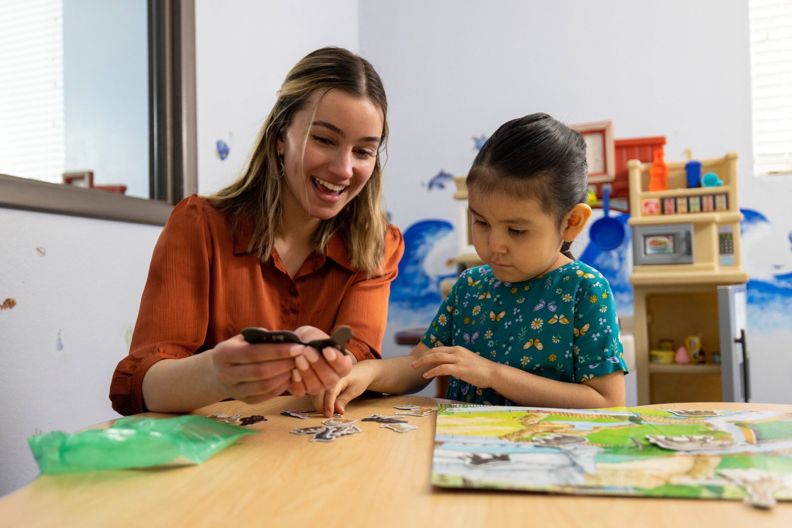 An NAU College of Education student happily works with a young student.
