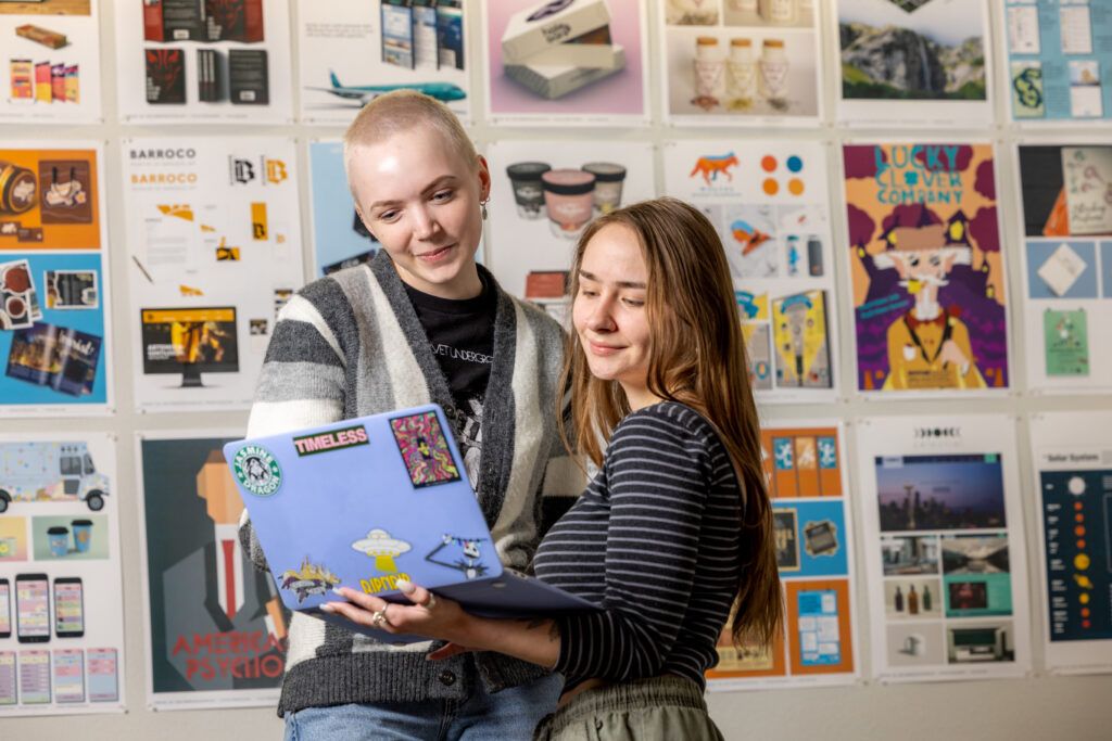 Two students work together on visual communication designs in the NAU Visual Design lab.