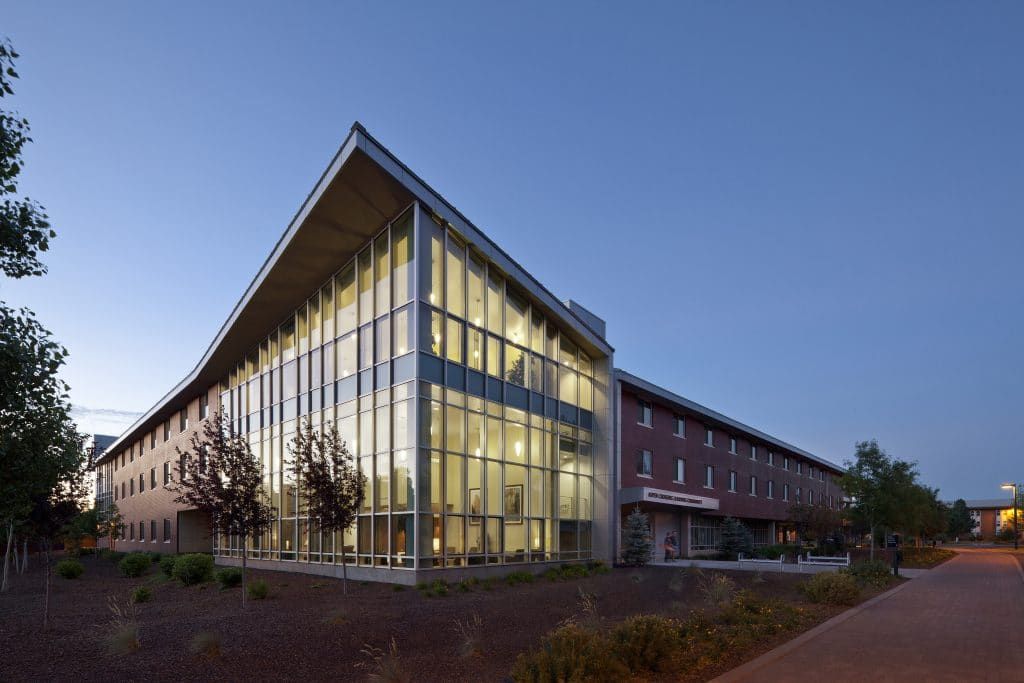 Exterior of Calderon Hall at dusk with the lobby lights on.