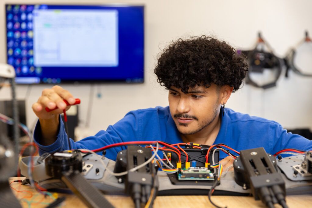 An engineering student studies robotics in the learning resource center.