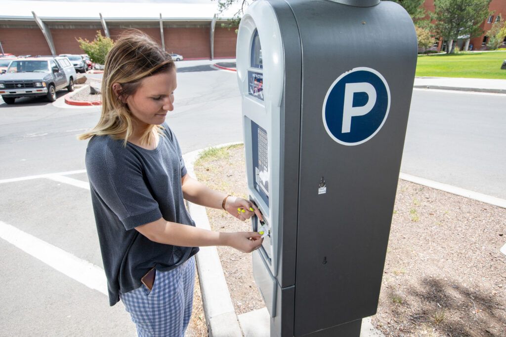 N A U student purchasing a parking pass at a parking machine.