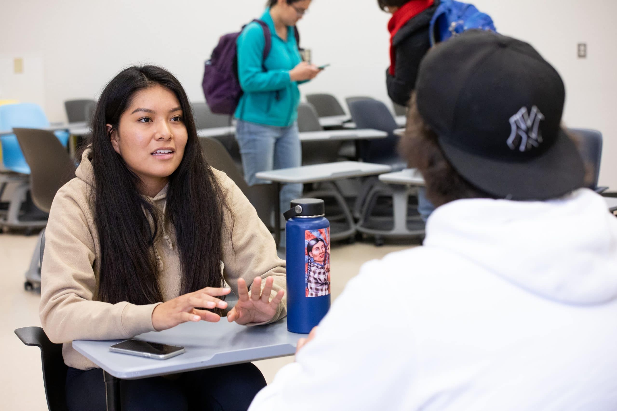 Students talking to each other at desks.