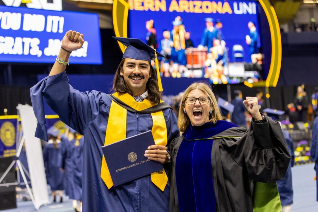 An N A U student cheers with their favorite professor during Spring Commencement in Flagstaff.